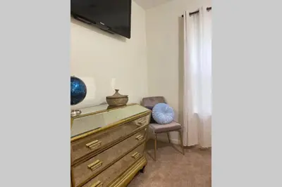 a bedroom with a dresser with a tv and a chair at Bailee's House in Monroe in Monroe