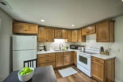 a kitchen with wooden cabinets and a white refrigerator at Cozy Home on 17 Acres, 3 Miles to Downtown! in Fort Wayne