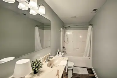 a bathroom with a sink and a toilet and a mirror at Cozy Home on 17 Acres, 3 Miles to Downtown! in Fort Wayne