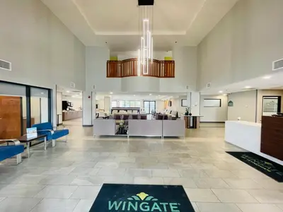 a large lobby with a dining area and a living room at Wingate by Wyndham Parkersburg-Vienna in Parkersburg
