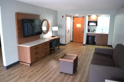 a hotel room with a desk and a couch at Wingate by Wyndham Parkersburg-Vienna in Parkersburg