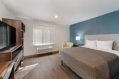 a bedroom with a bed and a flat screen tv at WoodSpring Suites Dayton North in Dayton
