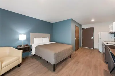 a bedroom with a bed and a couch in a room at WoodSpring Suites Dayton North in Dayton
