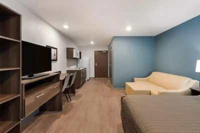a hotel room with a bed and a television at WoodSpring Suites Dayton North in Dayton
