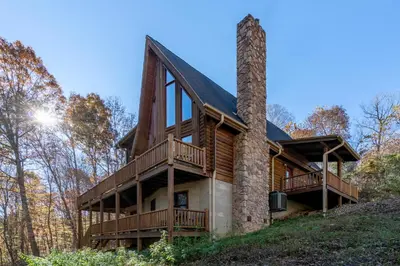 a log home with a chimney and decks at Creekwood Chalet - Hocking Hills with Hot Tub and Near Hiking in South Bloomingville