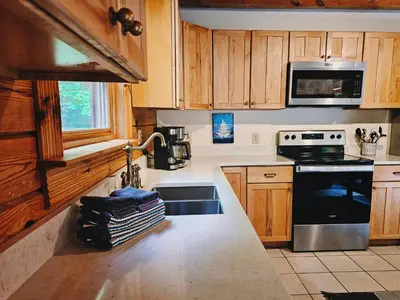 a kitchen with a sink and a stove at Creekwood Chalet - Hocking Hills with Hot Tub and Near Hiking in South Bloomingville