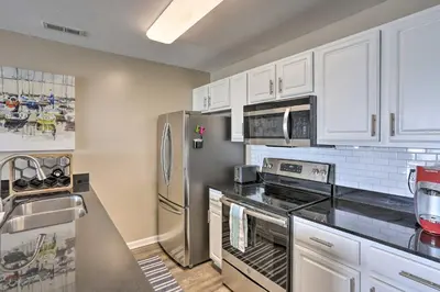 a kitchen with stainless steel appliances and white cabinets at Middle Bass Condo with Balcony, Lake Erie Views in Put-in-Bay