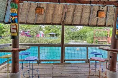 a view of a swimming pool from a deck with stools at Middle Bass Condo with Balcony, Lake Erie Views in Put-in-Bay