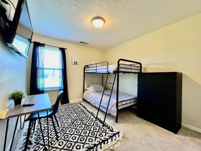 a bedroom with two bunk beds and a desk at Benji's House in Monroe