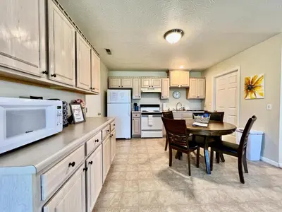 a large kitchen with a table and a microwave at Benji's House in Monroe