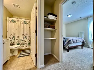 a bathroom with a toilet and a bed in a room at Benji's House in Monroe