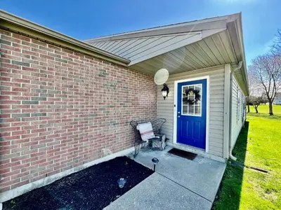 a brick house with a blue door and a bench at Benji's House in Monroe