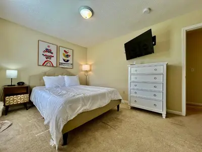 a bedroom with a bed and a dresser with a television at Benji's House in Monroe
