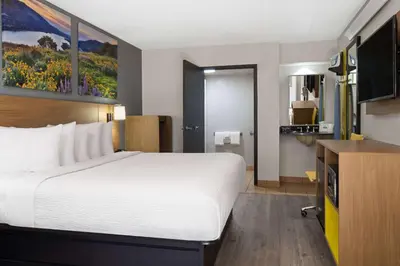 a hotel room with a large bed and a television at Days Inn by Wyndham Columbus Worthington in Columbus