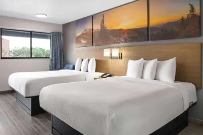 a hotel room with two beds and a painting on the wall at Days Inn by Wyndham Columbus Worthington in Columbus