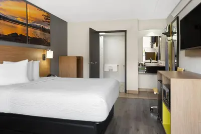 a hotel room with a large bed and a bathroom at Days Inn by Wyndham Columbus Worthington in Columbus
