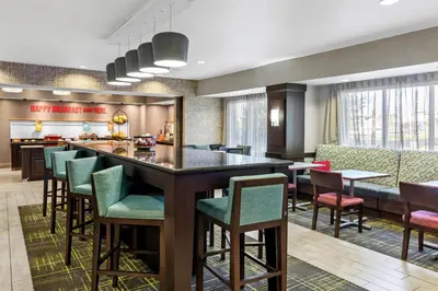 a lobby with a bar with chairs and tables at Hampton Inn Middletown in Middletown
