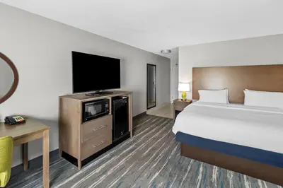 a hotel room with a bed and a flat screen tv at Hampton Inn Middletown in Middletown