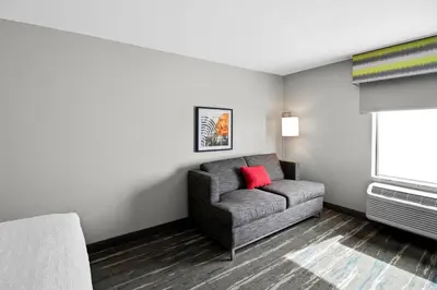 a living room with a chair and a window at Hampton Inn Middletown in Middletown