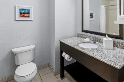 a bathroom with a toilet and a sink at Hampton Inn Middletown in Middletown