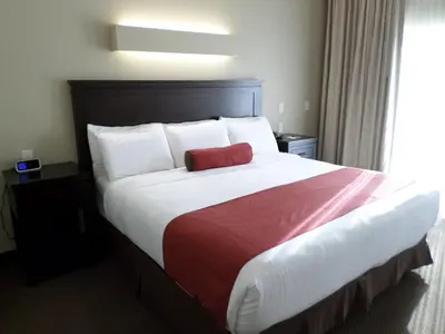 a hotel room with a large bed with a red pillow at Berlin Grande Hotel in Berlin