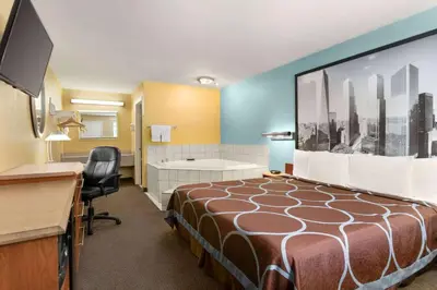 a hotel room with a bed and a desk at Super 8 by Wyndham Findlay in Findlay