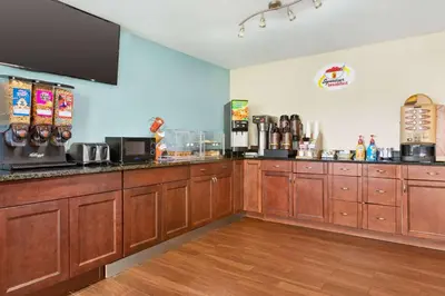 a kitchen with wooden cabinets and a counter top at Super 8 by Wyndham Findlay in Findlay