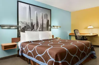 a hotel room with a bed with a picture on the wall at Super 8 by Wyndham Findlay in Findlay