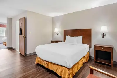 a hotel room with a large bed and a door at Country Inn & Suites by Radisson, Pickerington, OH in Pickerington