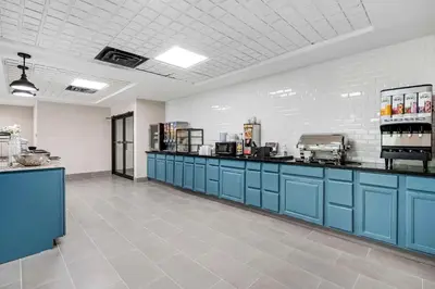 a large kitchen with blue cabinets in a room at Country Inn & Suites by Radisson, Pickerington, OH in Pickerington