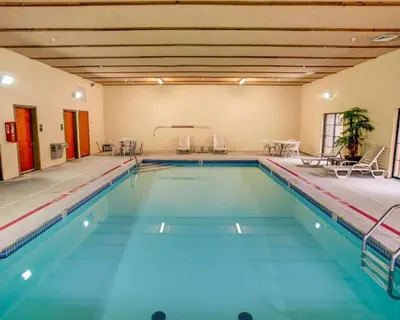 a large swimming pool with blue water in a building at Comfort Suites Pittsburgh Airport in Coraopolis