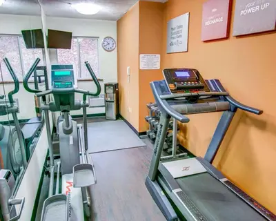 a gym with treadmills and machines in a room at Comfort Suites Pittsburgh Airport in Coraopolis