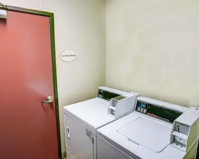 a room with a washing machine and a red door at Comfort Suites Pittsburgh Airport in Coraopolis