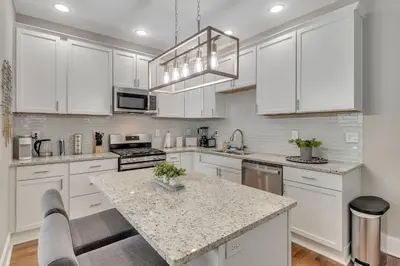 a kitchen with white cabinets and a marble counter top at Recently Renovated Home in the Heart of Bellevue! home in Bellevue