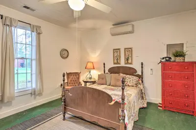 a bedroom with a bed and a red dresser at Rustic Cabin in the Woods 2-Acre Fishing Pond! in Burlington