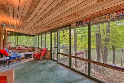 a screened in porch of a tree house with windows at Rustic Cabin in the Woods 2-Acre Fishing Pond! in Burlington