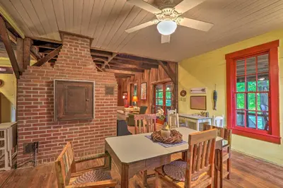 a dining room with a table and a ceiling fan at Rustic Cabin in the Woods 2-Acre Fishing Pond! in Burlington