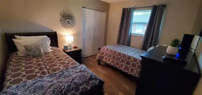 a bedroom with two beds and a window and a mirror at A great newly renovated place to stay in Franklin in Franklin