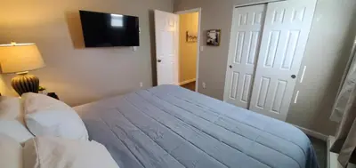 a bedroom with a blue bed with a television on the wall at A great newly renovated place to stay in Franklin in Franklin