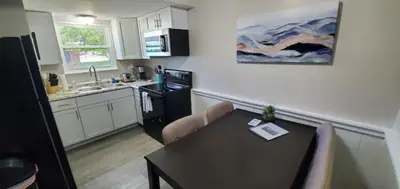a kitchen with a table and chairs and a kitchen with a sink at A great newly renovated place to stay in Franklin in Franklin