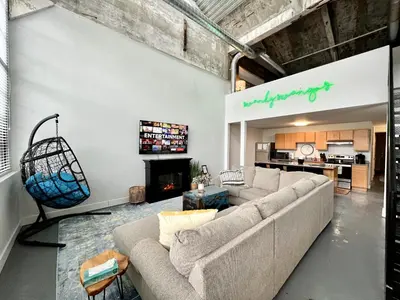 a living room with a couch and a fireplace at Swanky loft at Historic Peters Cartridge Factory in Maineville