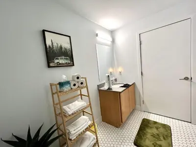 a bathroom with a sink and a desk with a mirror at Swanky loft at Historic Peters Cartridge Factory in Maineville