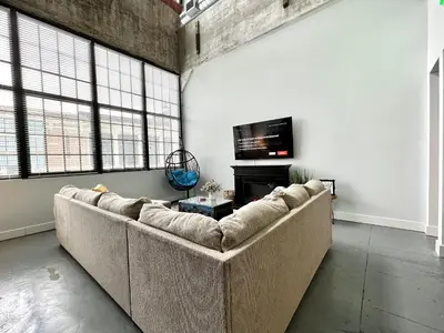 a living room with a couch and a tv at Swanky loft at Historic Peters Cartridge Factory in Maineville