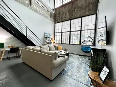 a living room with a couch and some windows at Swanky loft at Historic Peters Cartridge Factory in Maineville