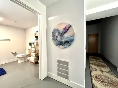 a bathroom with a toilet and a plate on the wall at Swanky loft at Historic Peters Cartridge Factory in Maineville