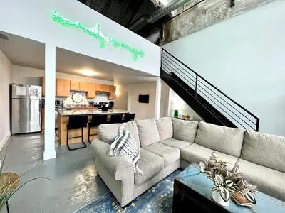 a living room with a couch and a kitchen at Swanky loft at Historic Peters Cartridge Factory in Maineville
