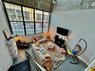 a living room with a couch and a table at Swanky Loft Near Kings Island, Brewery, Bike Trail in Maineville