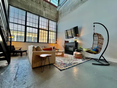 a living room with a couch and a chair at Swanky Loft Near Kings Island, Brewery, Bike Trail in Maineville