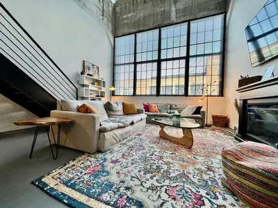 a living room with a couch and a fireplace at Swanky Loft Near Kings Island, Brewery, Bike Trail in Maineville