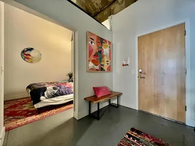 a bedroom with a bed and a door with a table at Swanky Loft Near Kings Island, Brewery, Bike Trail in Maineville